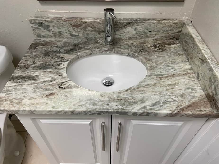 Updated bathroom with granite counters in condo flipping project