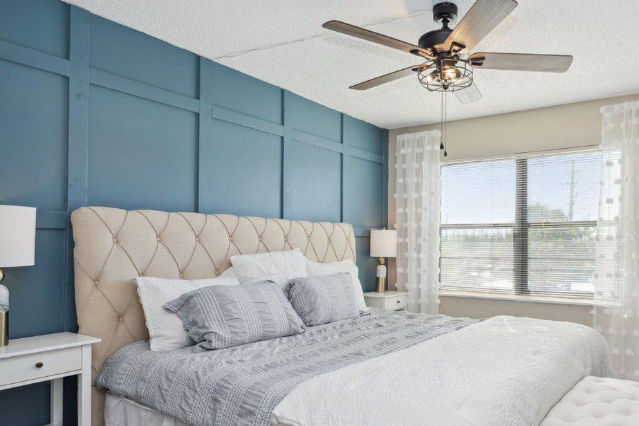 bedroom with blue accent wall created with DIY board and batten project in a renovated condo