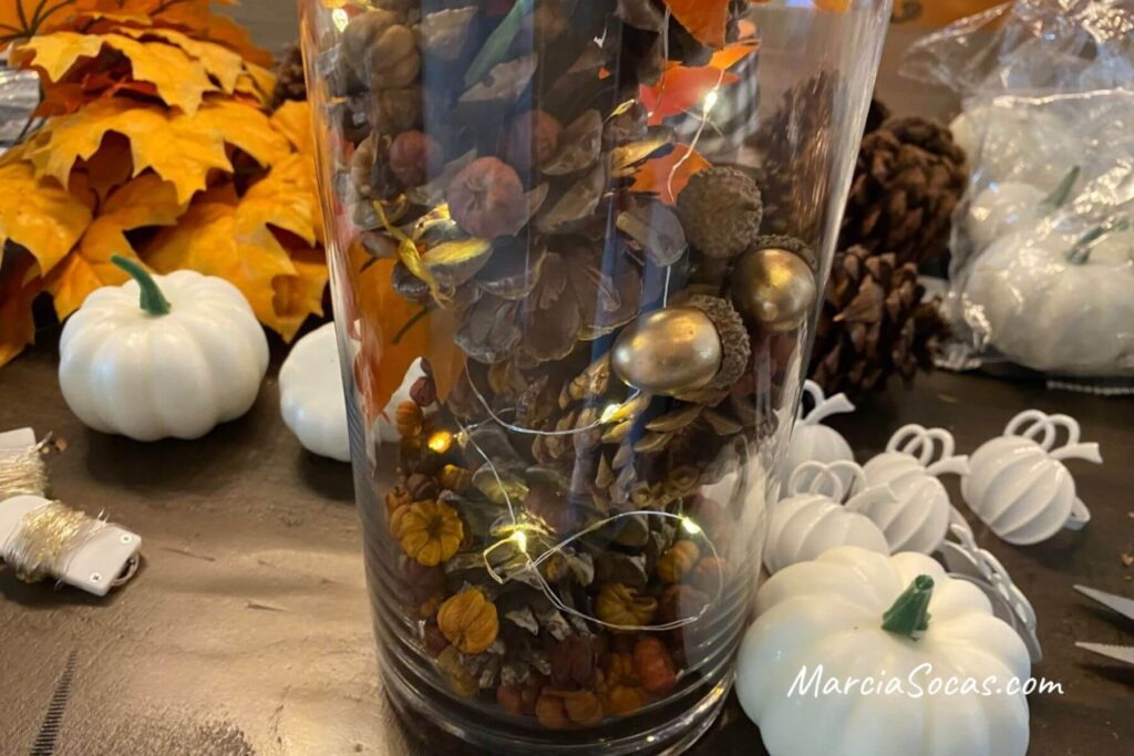 vase with fairy lights, pine cones, acorns, and potpourri