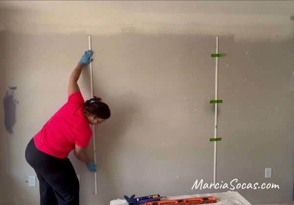 setting the vertical pieces of molding on the wall