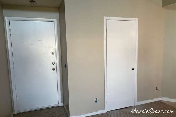before photo showing plain wall and door at entryway