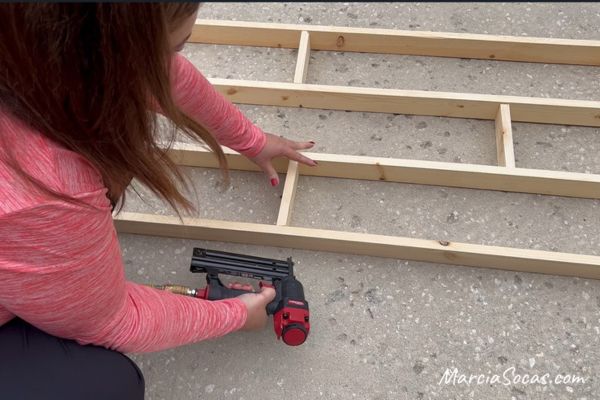 using a nail gun to secure wood in room divider